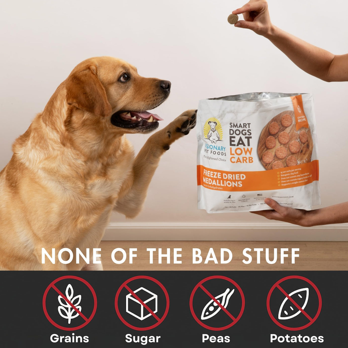 Dog reaching for a package of 'Smart Dogs Eat Low Care' freeze-dried medallions with a person holding the package.